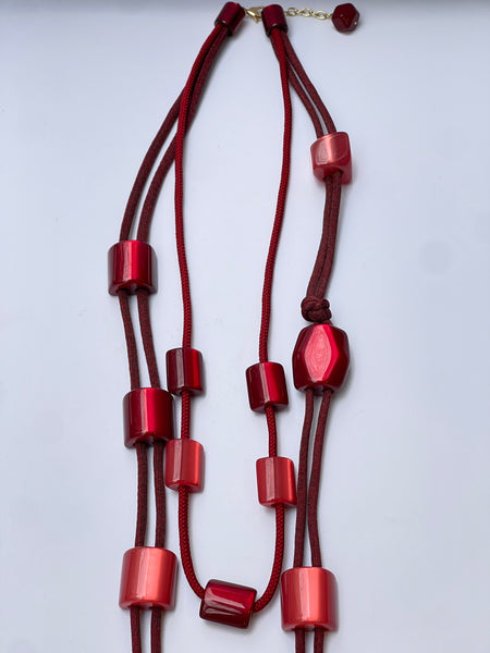 Collar largo en resina y cordón en gama rojo y granate
